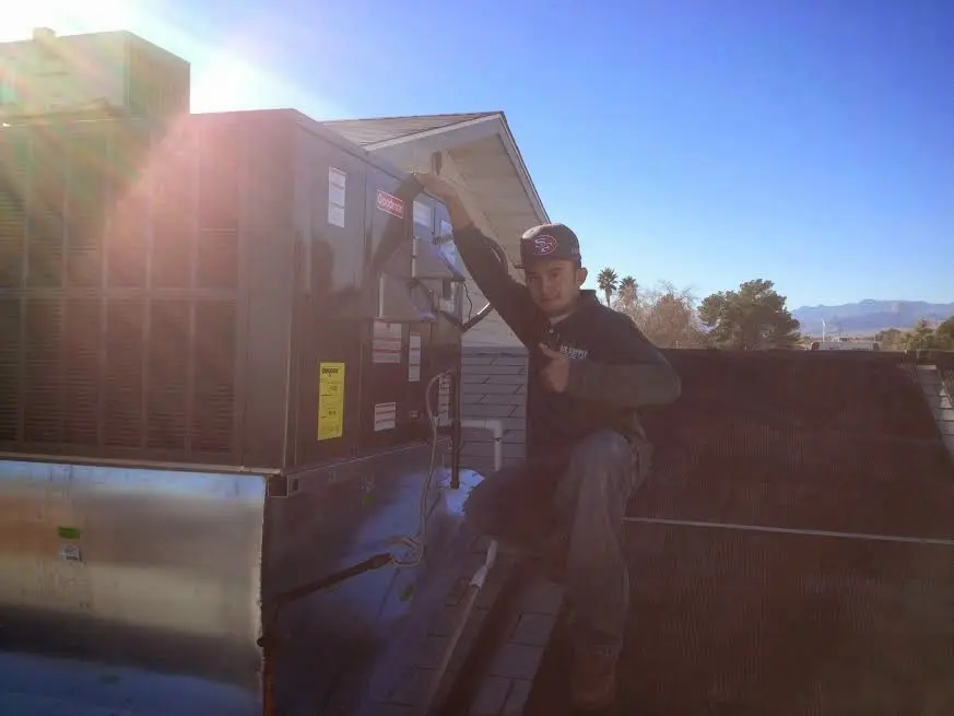 HVAC technician performing Boiler Repair on a rooftop unit in Mascoutah